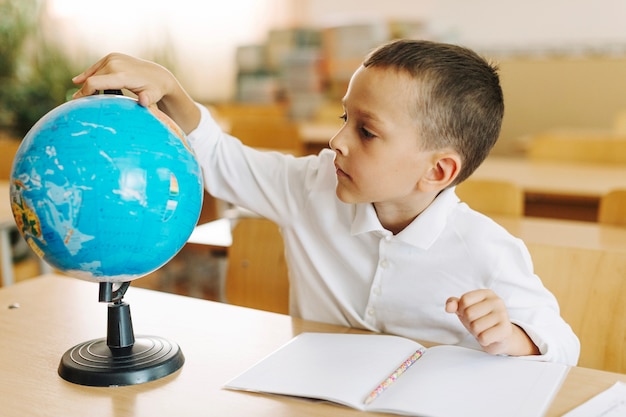 Schoolboy with globe at desk