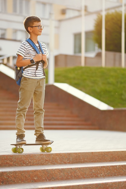 Schoolboy with a skate and backpack