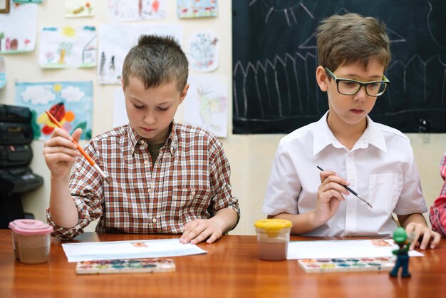 Schoolboys drawing in classroom