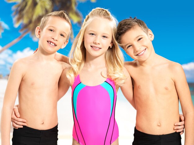 Schoolchild kids standing together in bright color swimwear.