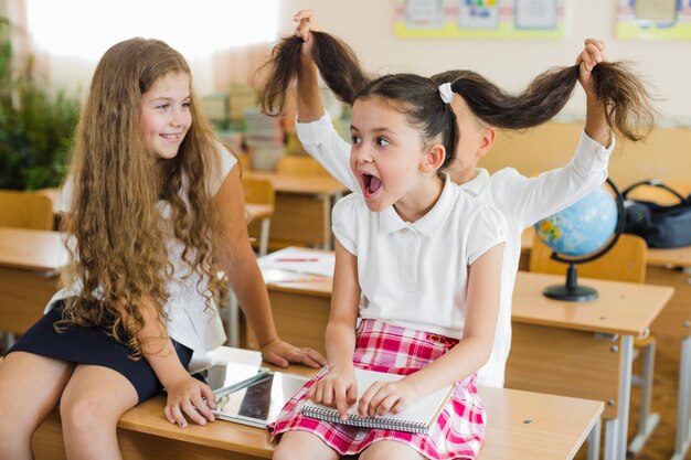 Schoolchildren playing tricks in classroom