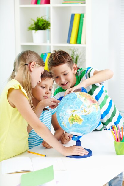Schoolchildren playing with globe
