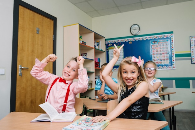 Schoolchildren sitting at desks posing