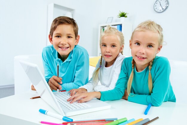 Schoolchildren typing on laptop