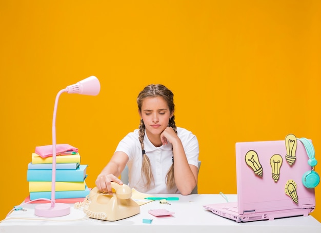 Schoolgirl on desk with laptop in memphis style