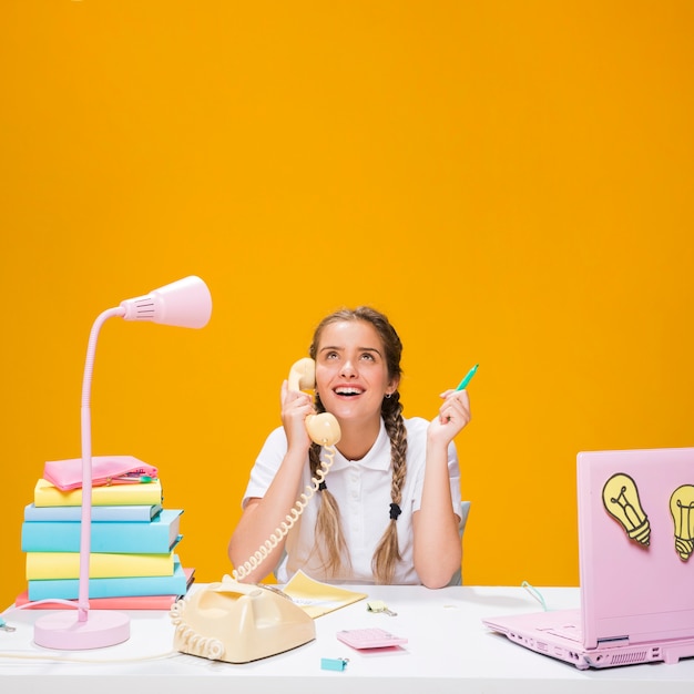 Free photo schoolgirl on desk with laptop in memphis style