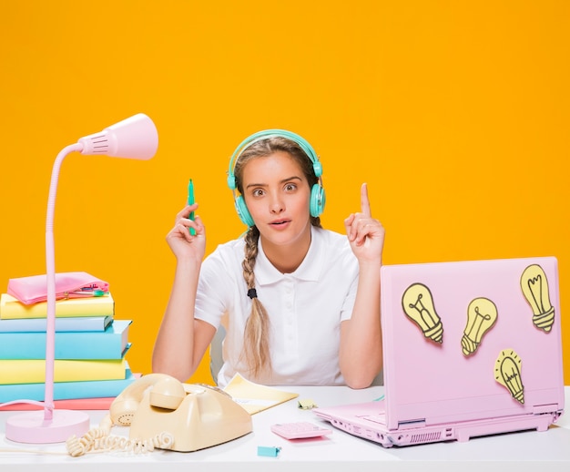 Schoolgirl on desk with laptop in memphis style