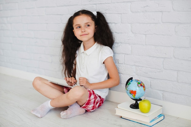 Free photo schoolgirl on floor with books