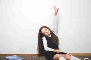 Free photo schoolgirl holding hand up