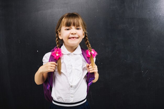 Schoolgirl making faces at chalkboard