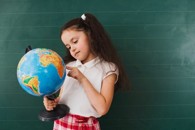 Schoolgirl posing with globe