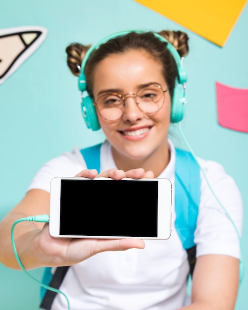 Free photo schoolgirl presenting a smartphone template