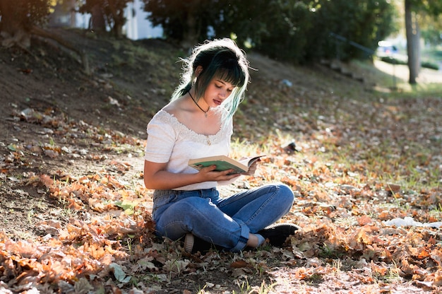 Schoolgirl reading on sunny hill