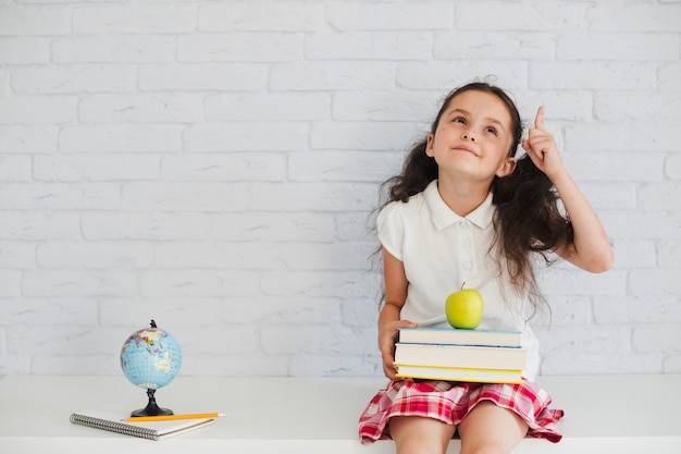 Schoolgirl sitting and pointing up