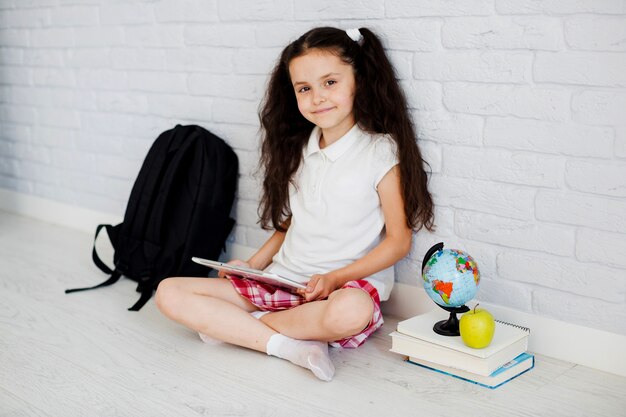 Schoolgirl sitting with tablet