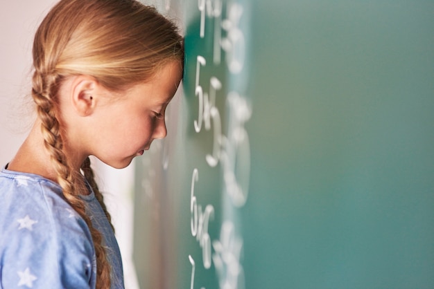 Free photo schoolgirl trying to understand formula