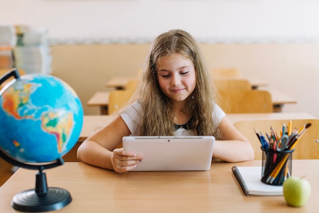 Foto gratuita scolara con tavoletta in classe