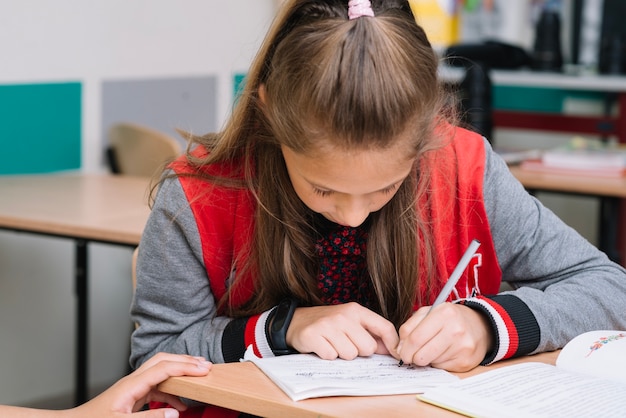 Free photo schoolgirl writing in class