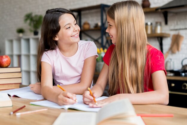 Schoolgirls doing homework and looking at each other