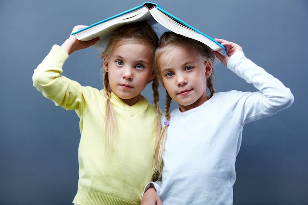 Schoolgirls playing with an open book