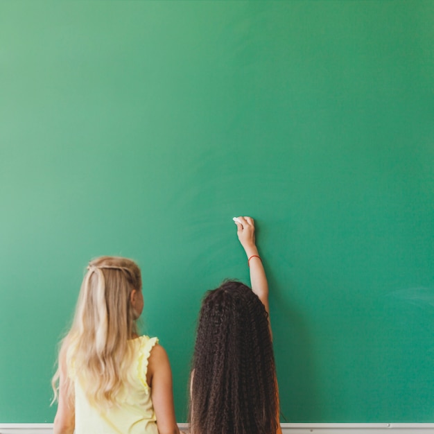 Schoolgirls standing at chalkboard