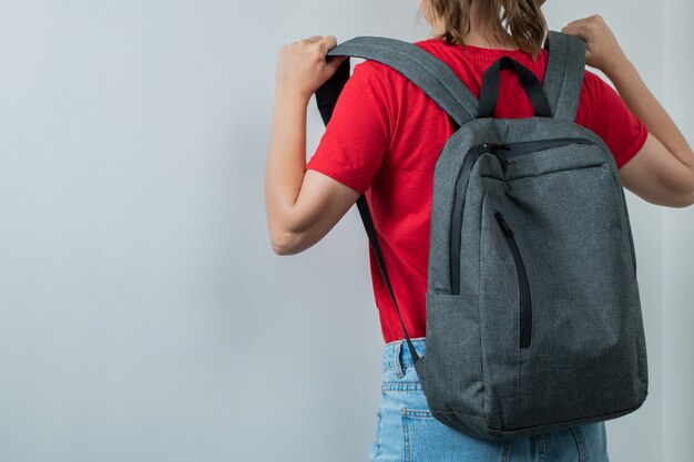 Schoolkid holding her backpack in the shoulders