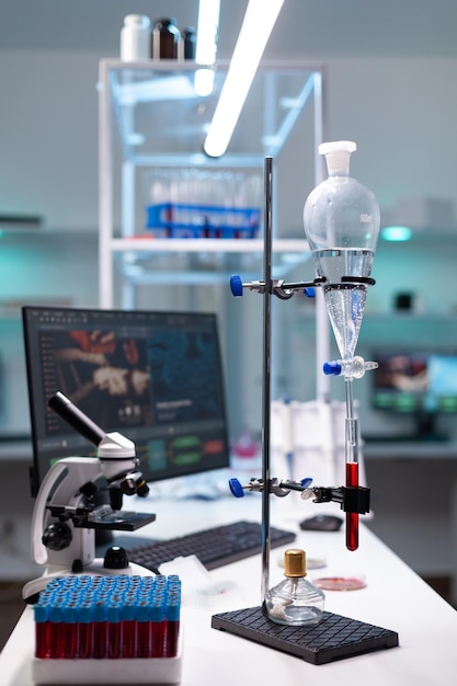 Science laboratory equipment and test tube with blood for healthcare development. Chemical dripping pipe with glass flask for analysis in biochemistry lab at clinic. Professional instruments