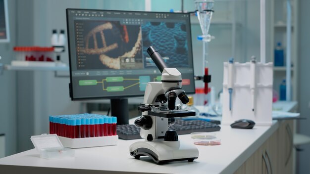 Scientific microscope on laboratory desk with researching instruments