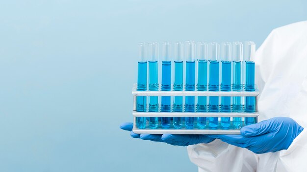 Scientist holding blue chemicals with copy space