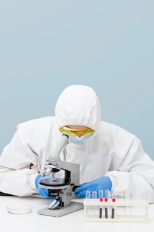 Ученый смотрит в микроскоп с копией пространства