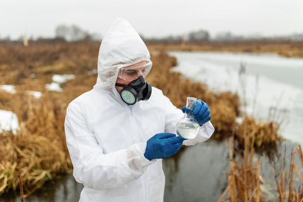 Foto gratuita scienziato che indossa il colpo medio della tuta protettiva