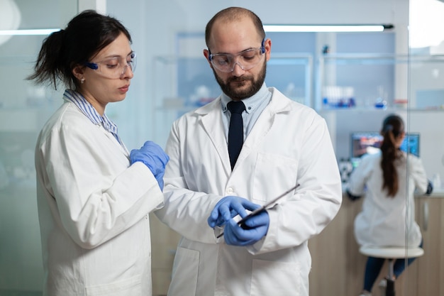 Женщина-ученый анализирует вирусную экспертизу с биологом-исследователем
