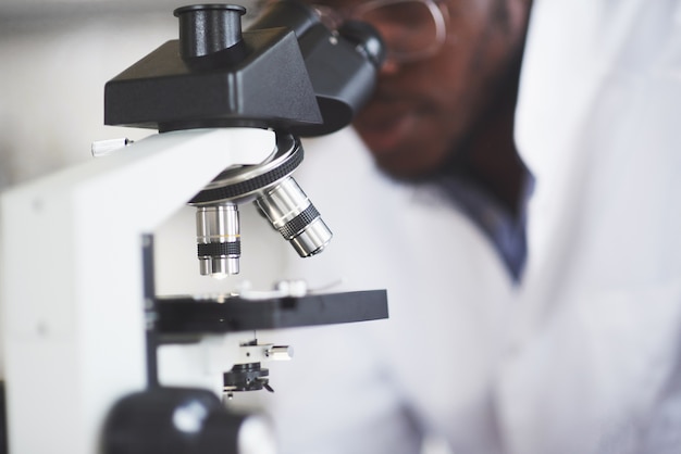 The scientist works with a microscope in a laboratory conducting experiments and formulas.