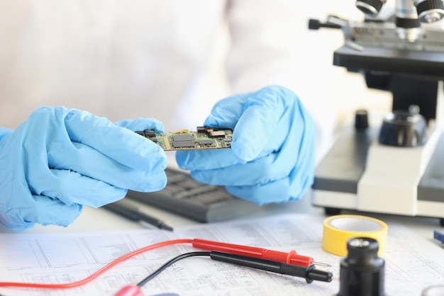Scientists holding microchip in rubber gloves in laboratory closeup