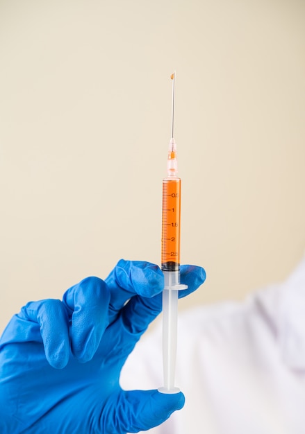 Scientists wearing masks and gloves Holding a syringe with a vaccine to prevent covid-19