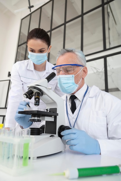 Scientists working with microscope in lab