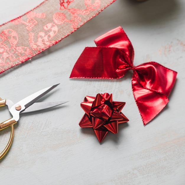 Scissors and bows near christmas ribbon