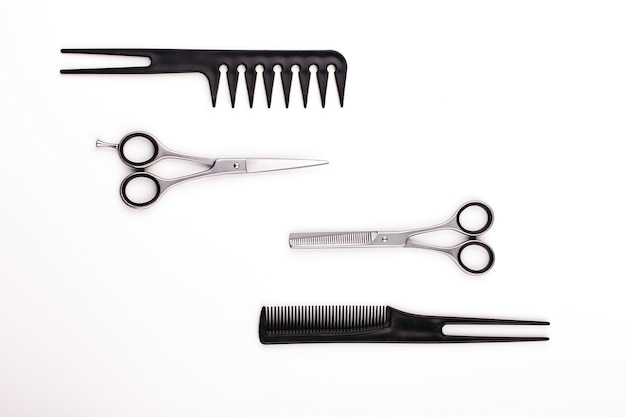 Scissors and combs for hair cut and treatment lie on a white table