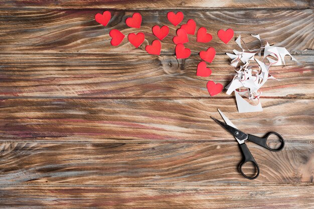 Scissors and hearts on lumber background