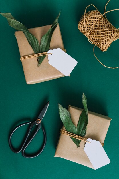 Scissors; spool and two gift boxes on green background