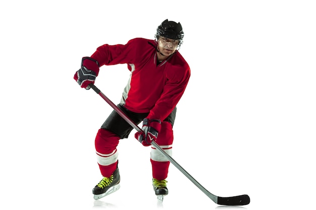 Scoring a goal. Male hockey player with the stick on ice court and white wall. Sportsman wearing equipment and helmet practicing. Concept of sport, healthy lifestyle, motion, movement, action.
