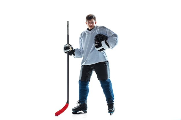 Подсчет очков. Молодой хоккеист мужского пола с клюшкой на ледовой площадке и белой предпосылке. Спортсмен в снаряжении и шлеме тренируется. Понятие спорта, здорового образа жизни, движения, движения, действий.