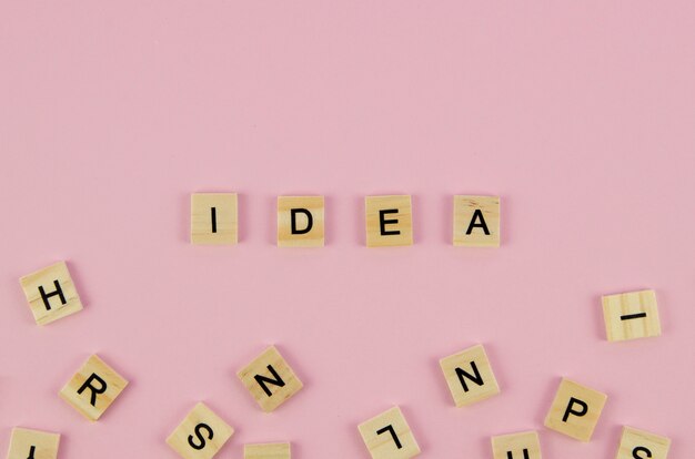 Scrabble letters and idea word concept on pink background