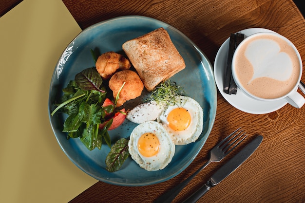 Free photo scrambled eggs on meat with fried potatoes and toast