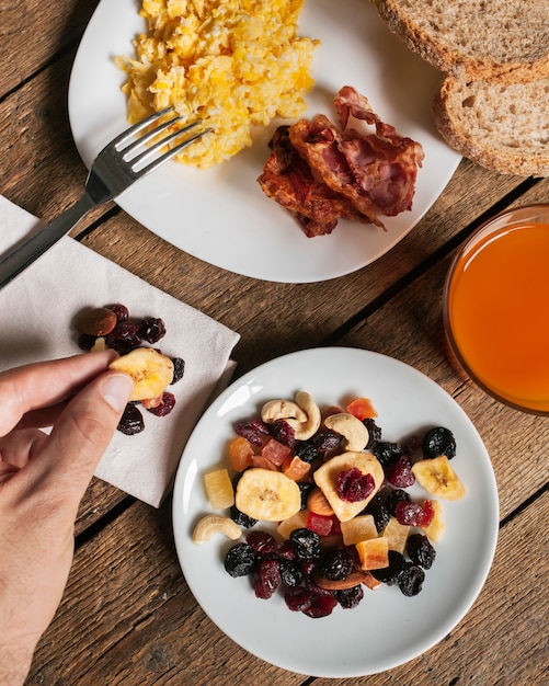 Scrambled eggs with bacon orange juice and dried fruits