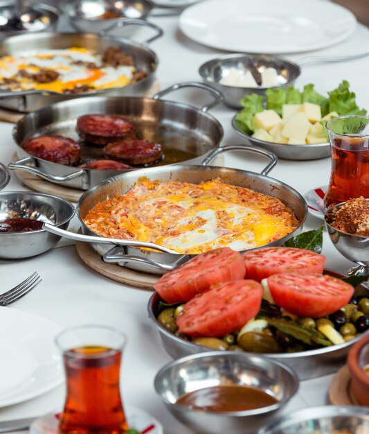 Scrambled eggs with tomatoes and fried sausages