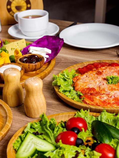テーブルの上のトマトと野菜のサラダとスクランブルエッグ