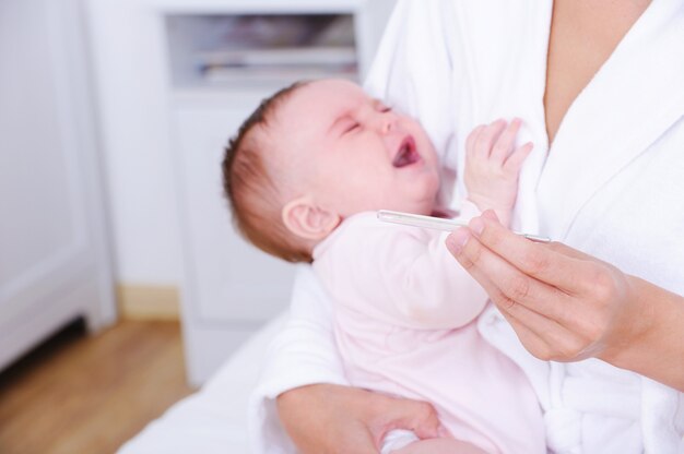 Screaming baby with thermometer