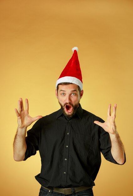 오렌지 배경에 산타 모자를 쓰고 크리스마스 남자 비명