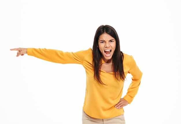 Screaming displeased young lady pointing.